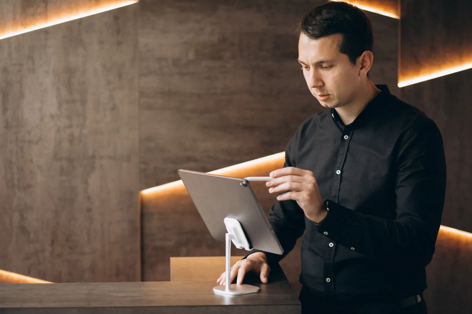 Recepcionista de hotel gestionando reservas en una tableta