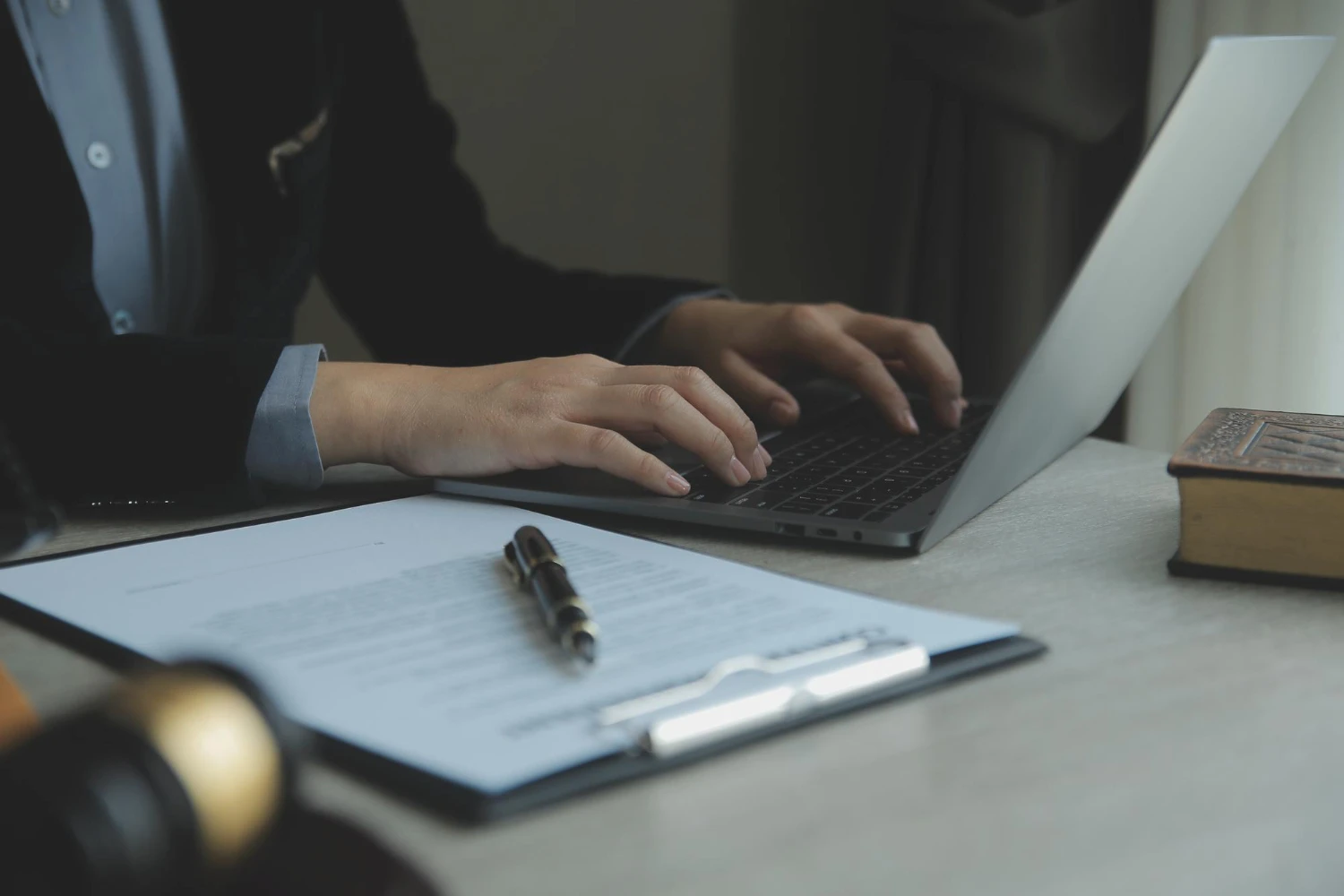 Abogado trabajando con un ordenador portátil y documentos legales