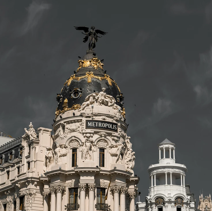 Fachada y cúpula del Edificio Metrópolis en Madrid bajo un cielo nublado