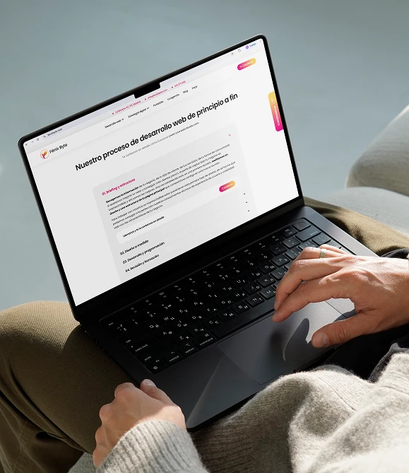 Persona consultando en un portátil qué incluye un presupuesto de desarrollo web